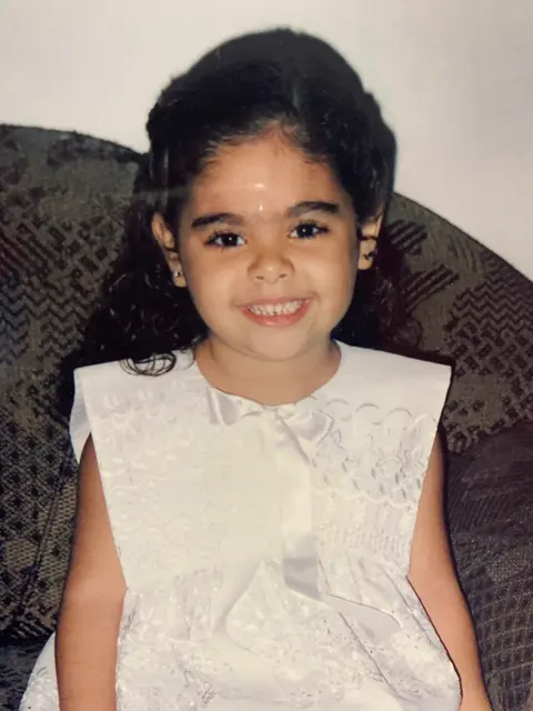 Desirée criança, sorrindo.